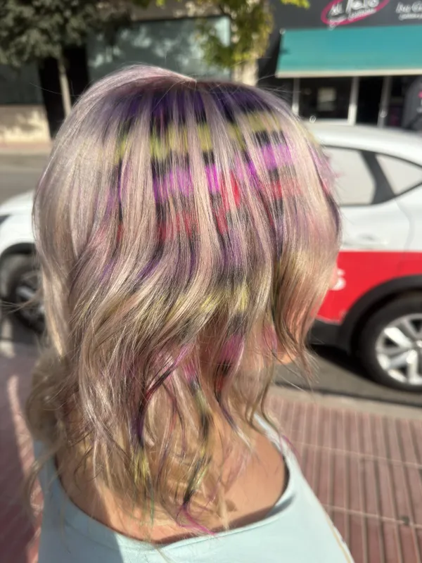 Melena rubia con mechones pastel en rosa, lila y verde · Al Pelo Estilistas