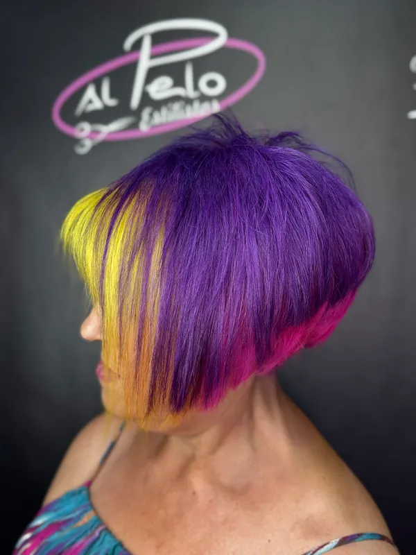Bob asimétrico en violeta con mechón amarillo y puntas fucsia · Al Pelo Estilistas