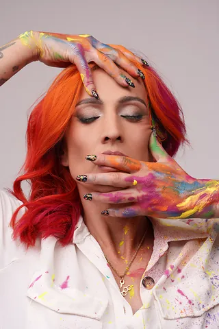 Isa con los ojos cerrados y las manos pintadas de colores sobre la cara