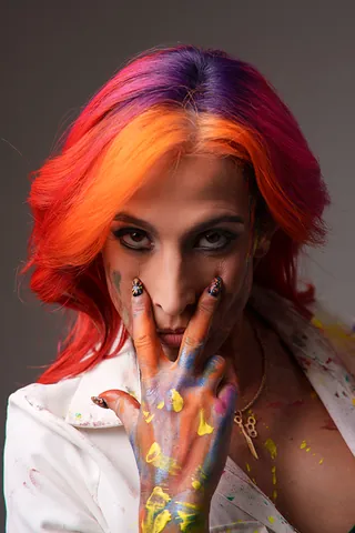 Isa con las manos pintadas sobre la boca y la melena de fuego